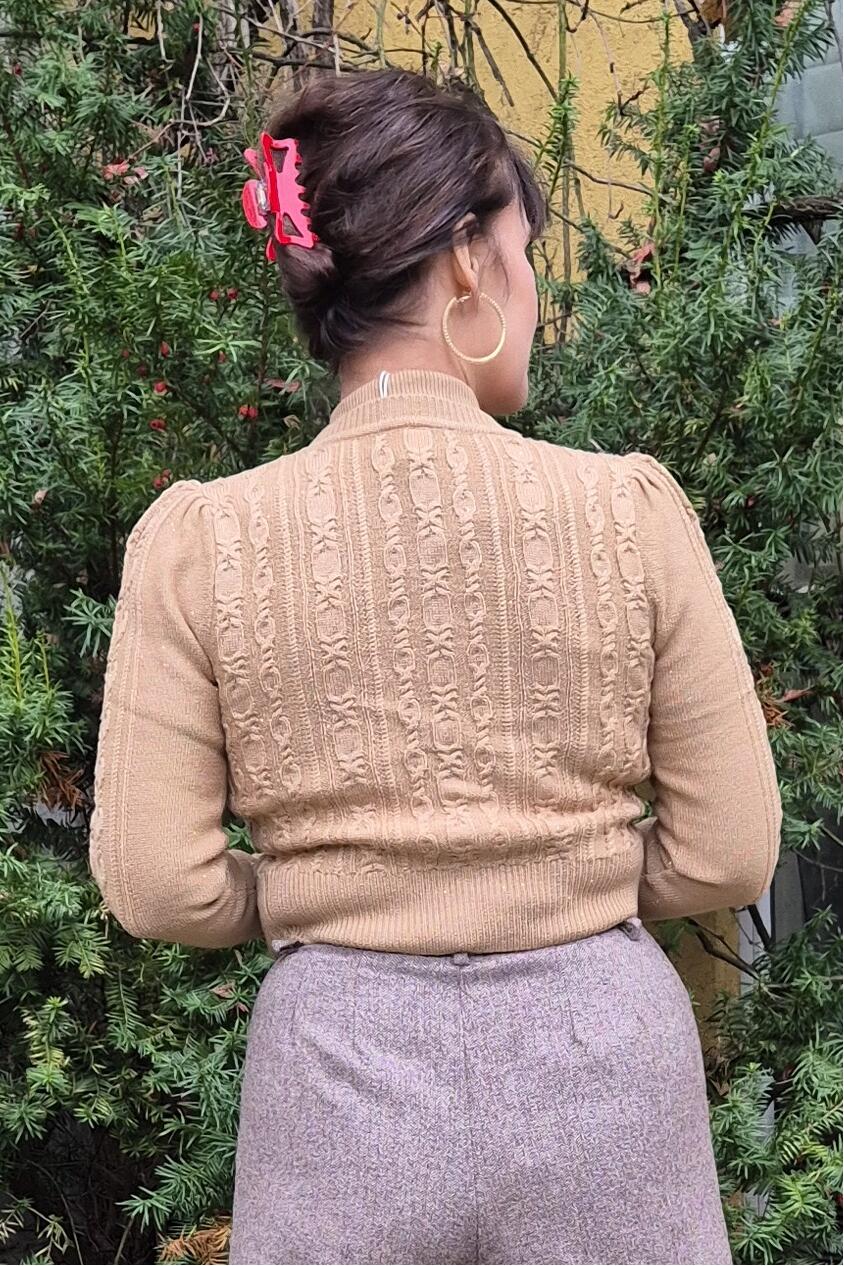 Gullfarget Ice Skater cardigan i merinoull fra Emmy. Bildet er av ryggen fra Manillusion i Oslo.