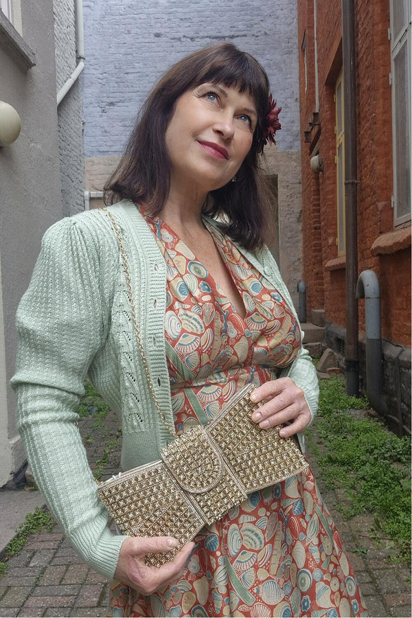 Sløyfeformet clutchveske i gull med stener i strass